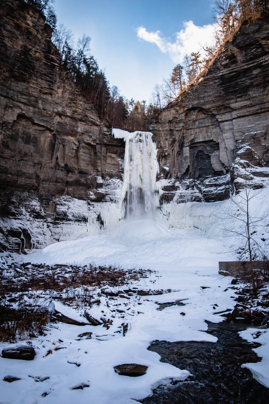 Another image of Taughannock Falls with surrounding snow and rock formations – A scenic winter view of Taughannock Falls, one of the Finger Lakes’ most famous waterfalls, standing tall amidst icy cliffs.