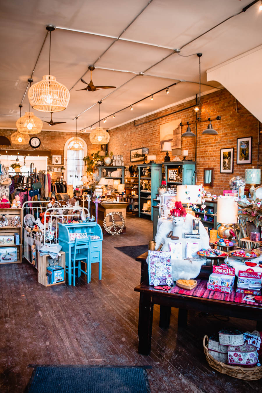 Image of a boutique shop with wooden floors, vintage decor, and hanging lights – A warm and inviting shop filled with unique gifts, home decor, and handcrafted items, perfect for a winter shopping experience in the Finger Lakes.