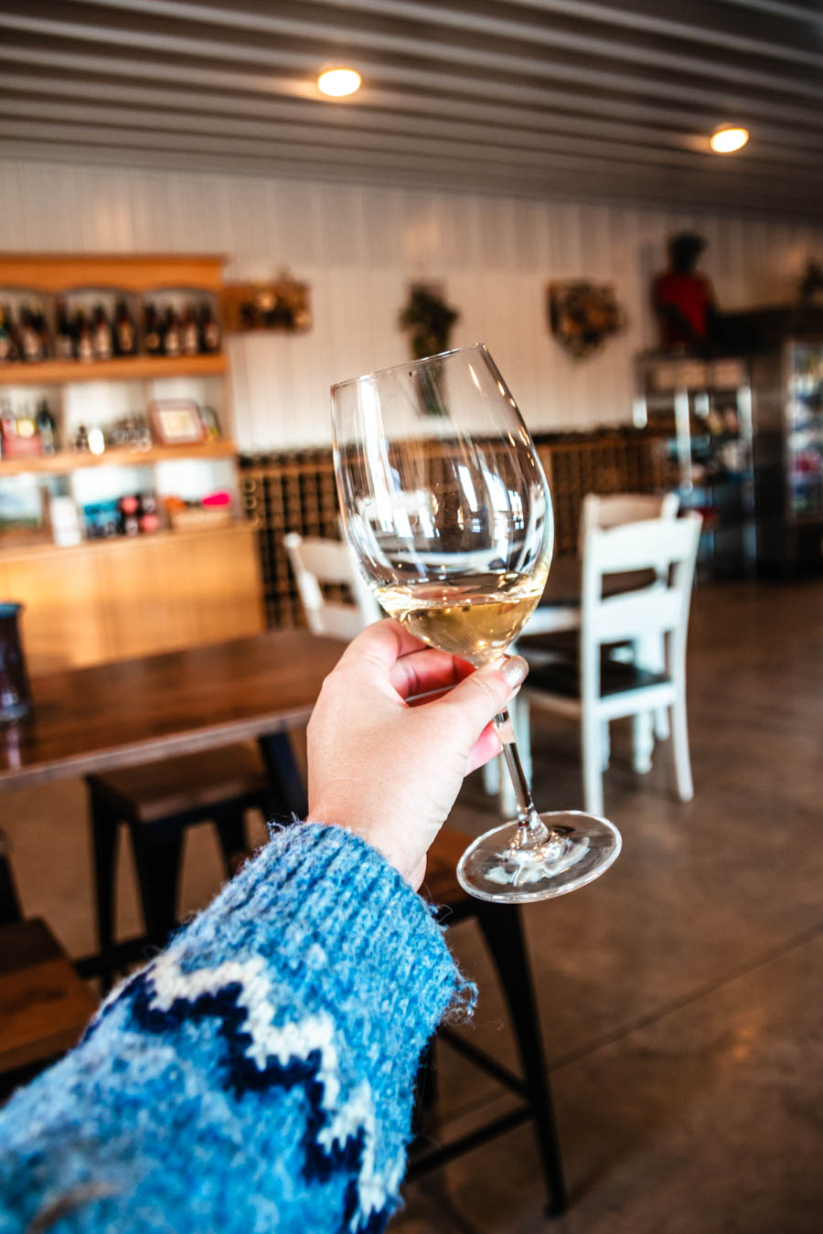 A women holding a glass of wine at Bet the Farm Winery in the Finger Lakes