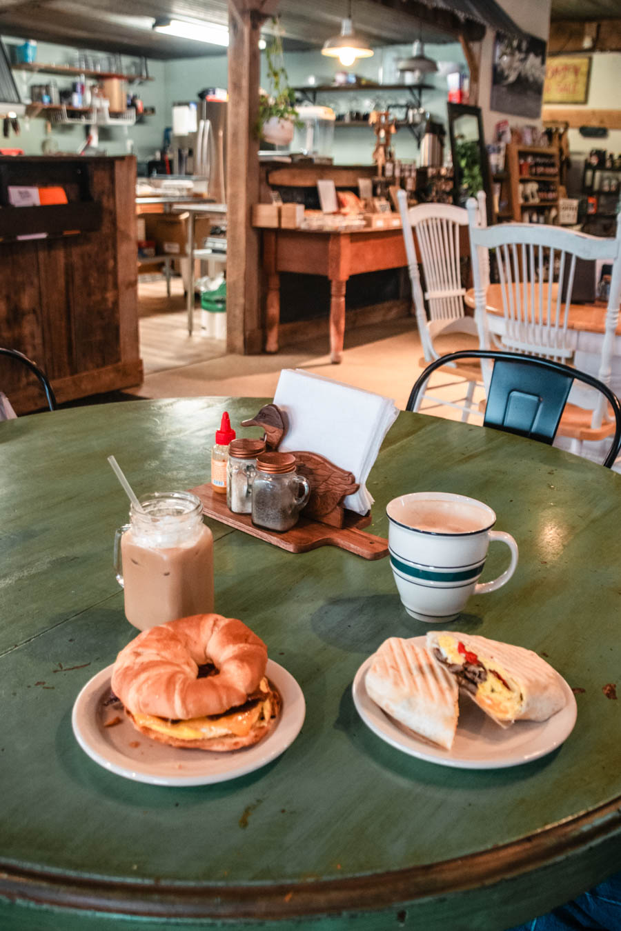 Delicious Winter Breakfast – A hearty breakfast spread with a croissant sandwich, panini, and warm coffee at a cozy café.