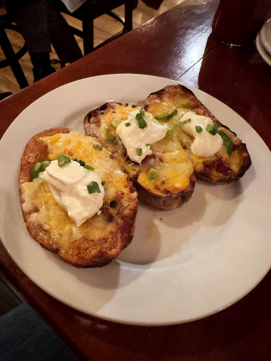 Loaded potato skins with sour cream and cheese – A comforting winter meal of crispy potato skins topped with melted cheese, green onions, and sour cream.